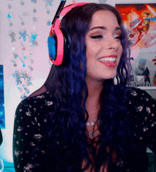 a woman with purple hair is wearing pink headphones and smiling