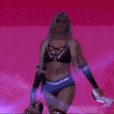 a woman in a black top and shorts is walking on a stage .