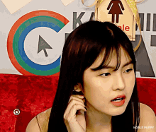 a woman is sitting in front of a colorful sign that says noble puppy