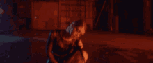 a woman in a fishnet top is kneeling on the floor