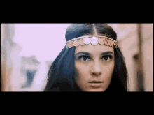 a woman is wearing a headband with coins on it