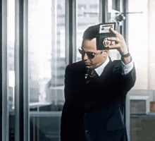 a man in a suit and tie takes a picture of himself