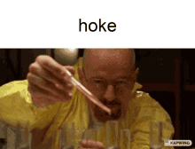 a man in a yellow jacket is holding a pipette and the word hoke is on the top