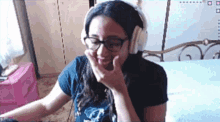 a woman wearing glasses and headphones is smiling