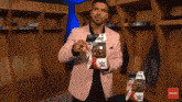 a man in a pink suit holds a wwe action figure