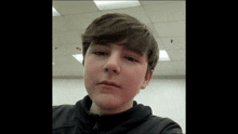 a young boy is taking a selfie in a room with a ceiling light .