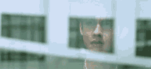 a close up of a man 's face behind a glass window .