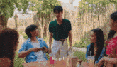 a group of people are sitting at a table and one of them is saying hey girls