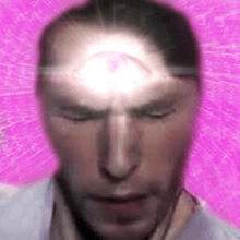 a close up of a man 's face with a third eye shining on his head .