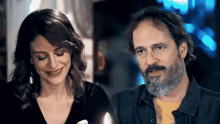 a man and a woman are standing next to each other and smiling at each other .