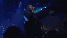 a man singing into a microphone on stage