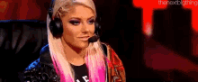 a woman wearing headphones and a microphone is sitting on a chair .