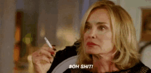 a woman is holding a cigarette in her hand and says `` oh shit '' .
