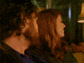 a man with a beard and a woman with red hair are sitting next to each other