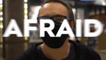 a man wearing glasses and a mask with the word afraid in front of him