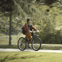 a person wearing a helmet is riding a bike down a road