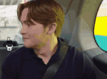 a man wearing a seat belt is sitting in the back seat of a car