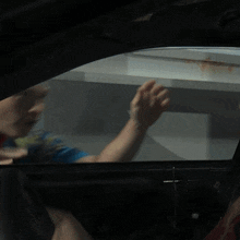 a person sitting in a car looking out the window