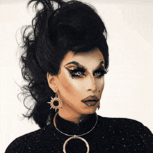 a drag queen wearing a necklace with a circle on it