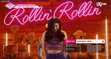a woman is dancing in front of a sign that says rollin rollin