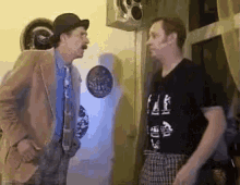 two men are standing next to each other and one of them is wearing a black shirt that says fall