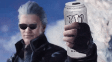 a man with sunglasses is holding a can of monster energy drink .