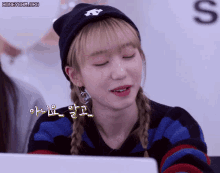 a woman wearing a beanie and a striped sweater is smiling
