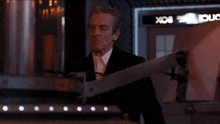a man in a suit and tie is standing in front of a machine that says box .