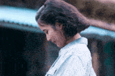 a woman with curly hair wearing a light blue shirt