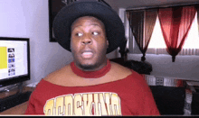 a man wearing a black hat and a red shirt that says san francisco