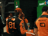 a man wearing a mclaren jacket with the number 81 on the back