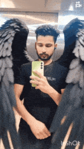 a man is taking a picture of himself with wings on his arms
