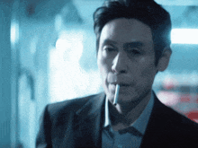 a man smoking a cigarette in a dark room