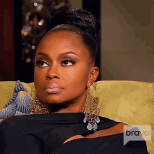 a woman sits in a chair with a bravo logo on the corner