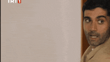 a close up of a man 's face with the trt logo in the background