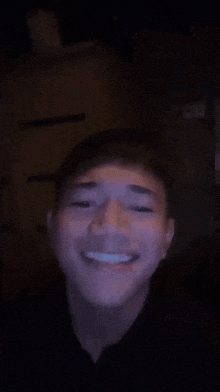 a young man is making a funny face in the dark .