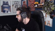 a man wearing headphones has a france jersey behind him