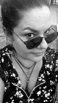 a woman wearing sunglasses and a necklace with a skull pendant