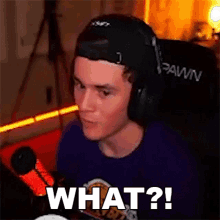 a young man wearing headphones and a baseball cap is sitting in front of a microphone and says what ?