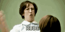 a woman wearing glasses is yelling at another woman in a classroom .