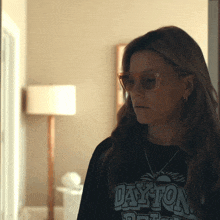 a woman wearing sunglasses and a black dayton shirt