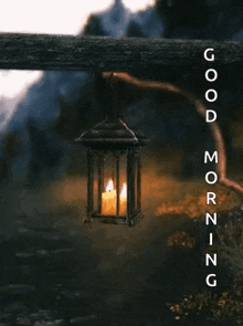 a lantern with a lit candle inside of it is hanging from a wooden fence .