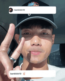 a man wearing a hat and a ring is giving the peace sign