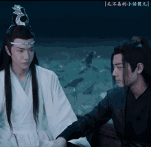 two men are standing next to each other with chinese writing on the bottom right