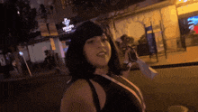 a woman is walking down a street in front of a pronto pizza restaurant