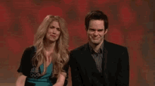a man and a woman are standing next to each other .