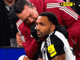 a soccer player is being helped by a man in a setanta sports shirt