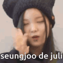 a close up of a woman wearing a hat and making a face .