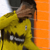 a man wearing a yellow jersey that says nationwide