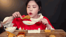 a woman is eating fried food with a spoon